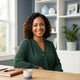 A friendly, diverse woman smiling confidently in a bright, modern interior setting with blue-toned decor.