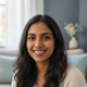 Close-up portrait of a smiling South Asian woman, looking friendly and trustworthy.